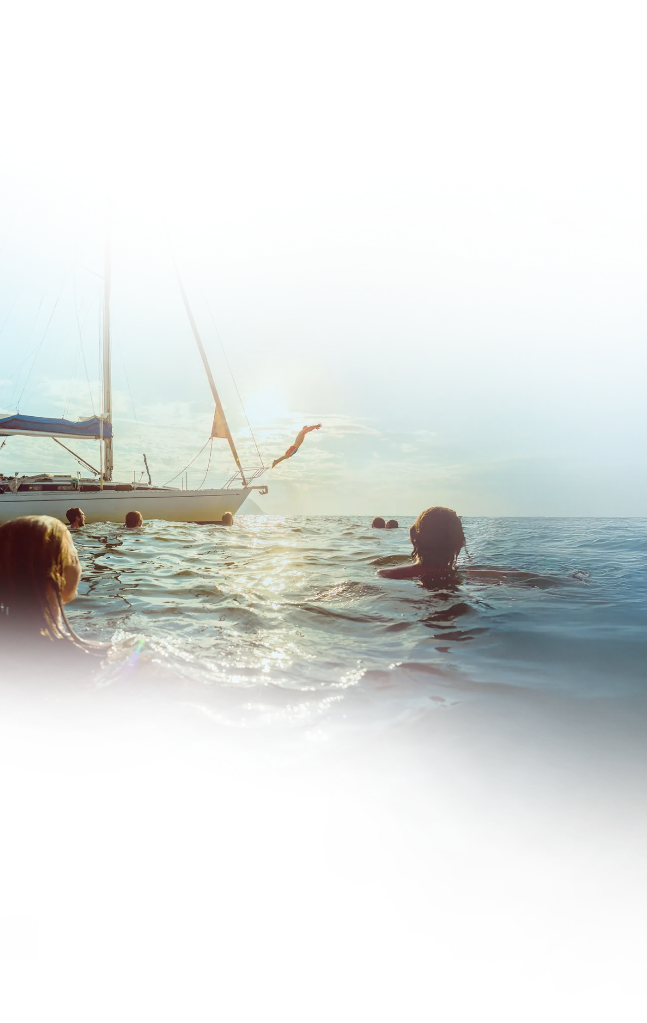 People in the water with a ship in the background